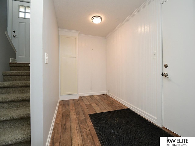 interior space featuring ornamental molding, stairs, baseboards, and dark wood-style flooring