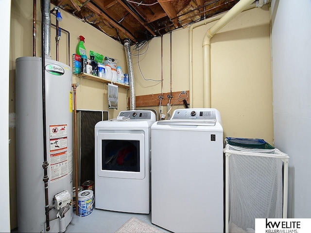 washroom featuring washing machine and dryer, gas water heater, and laundry area