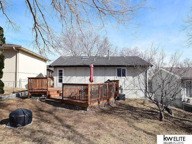 rear view of property with a wooden deck and fence