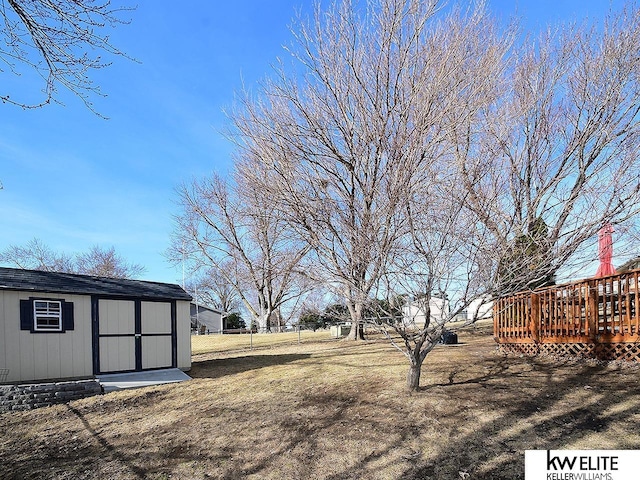 view of yard featuring a deck, an outdoor structure, and a shed