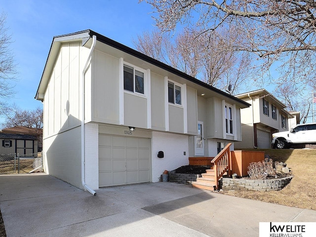 bi-level home with brick siding, concrete driveway, and an attached garage