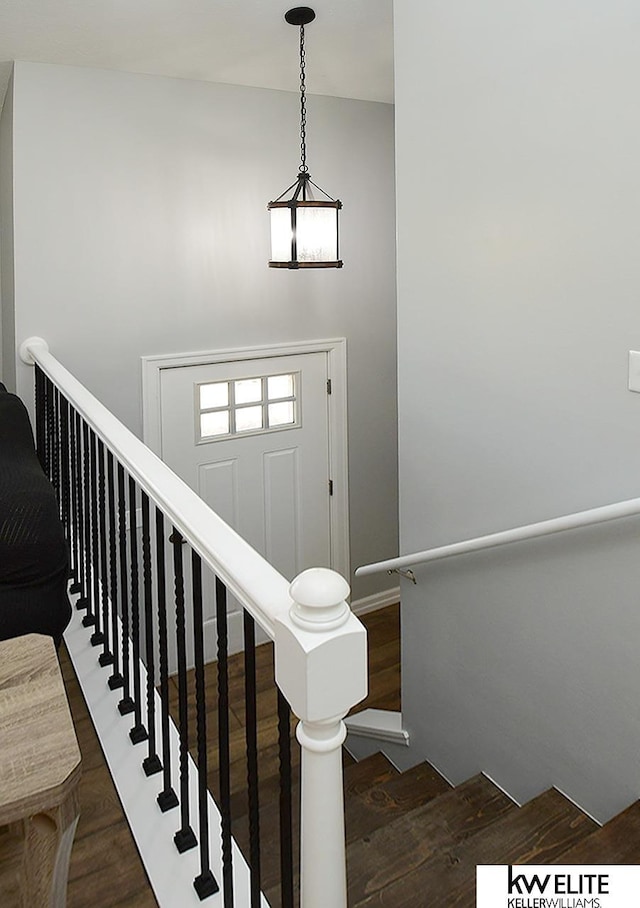 staircase with a high ceiling and wood finished floors