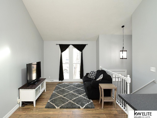 sitting room with an upstairs landing, baseboards, and wood-type flooring