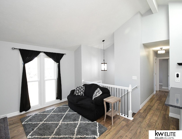 living room with beam ceiling, baseboards, wood-type flooring, and high vaulted ceiling