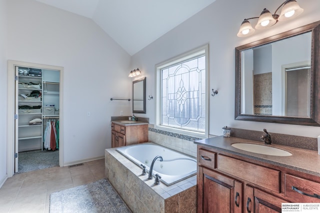 bathroom featuring a sink, two vanities, tile patterned flooring, and vaulted ceiling