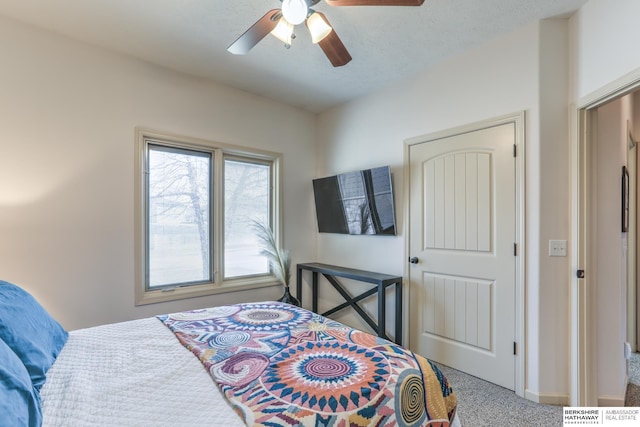 carpeted bedroom featuring a textured ceiling and ceiling fan