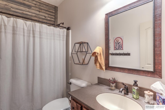 full bathroom featuring vanity, curtained shower, and toilet