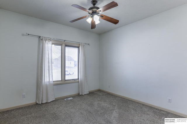 carpeted empty room featuring visible vents, a ceiling fan, and baseboards