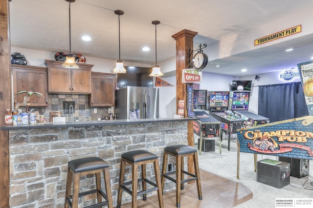 kitchen featuring pendant lighting, backsplash, recessed lighting, stainless steel fridge, and carpet floors