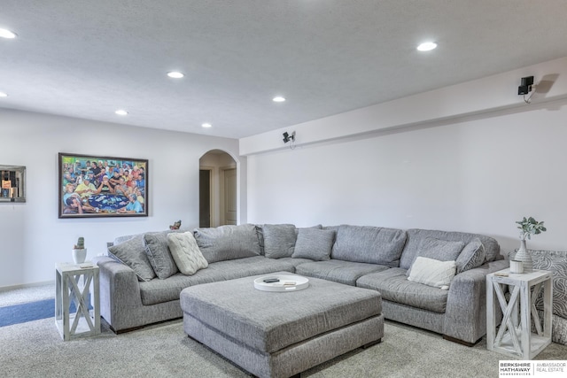 carpeted living area featuring recessed lighting and arched walkways