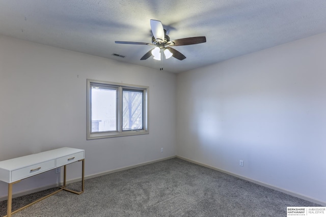 carpeted spare room featuring visible vents, baseboards, and a ceiling fan