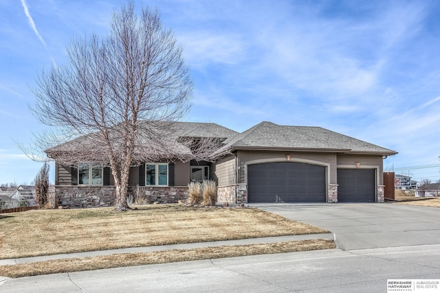 view of front of home featuring stone siding, driveway, a front yard, and a garage