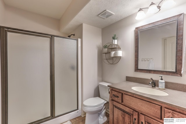 full bathroom featuring visible vents, toilet, a textured ceiling, a shower stall, and vanity