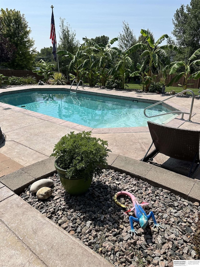 view of swimming pool featuring a fenced in pool, a patio, and fence