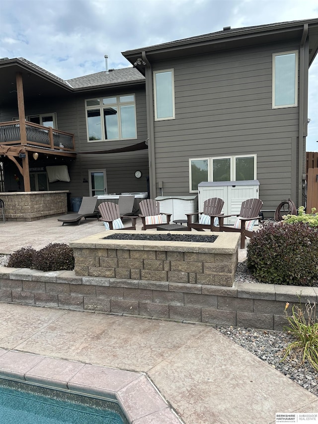 back of house featuring an outdoor pool, a fire pit, and a patio area