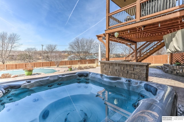 view of swimming pool featuring stairs, a fenced backyard, and a hot tub