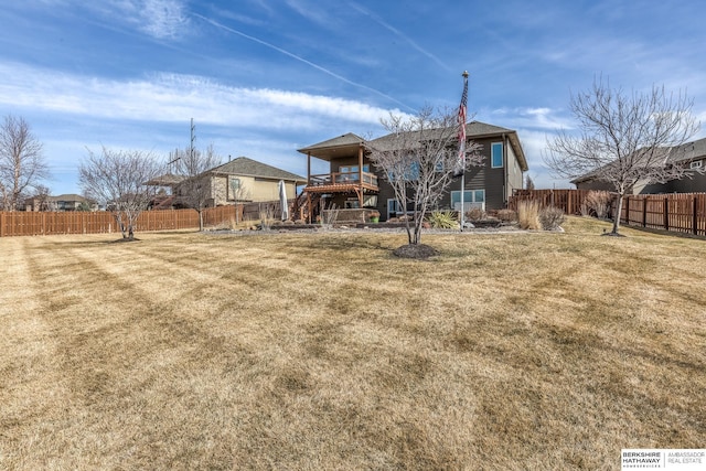 rear view of property featuring a yard and a fenced backyard