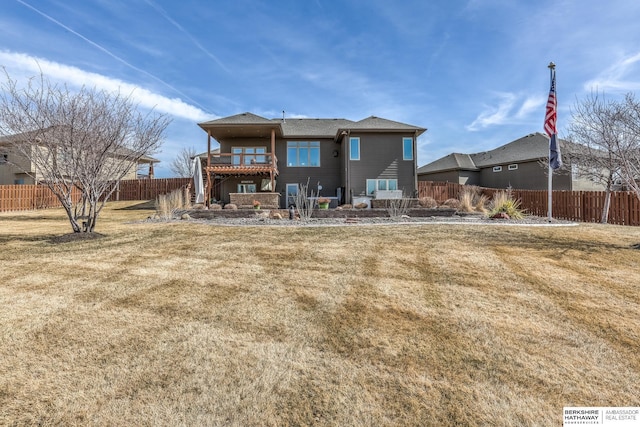 rear view of property featuring a lawn and a fenced backyard