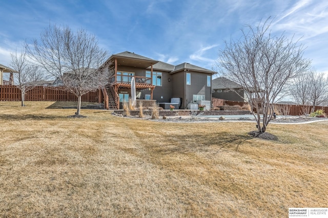 back of house with stairway, a lawn, a deck, and fence