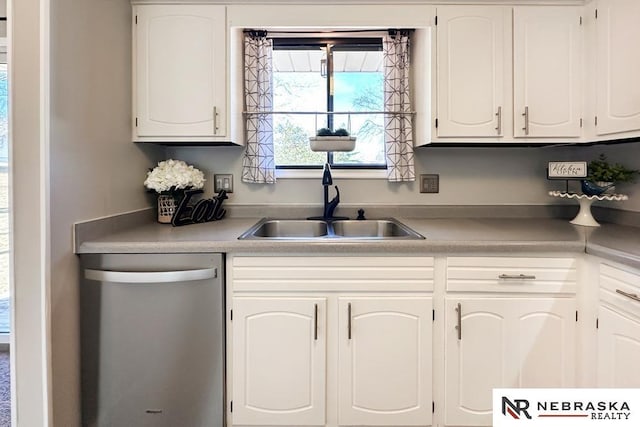 kitchen with a sink, dishwasher, white cabinets, and light countertops