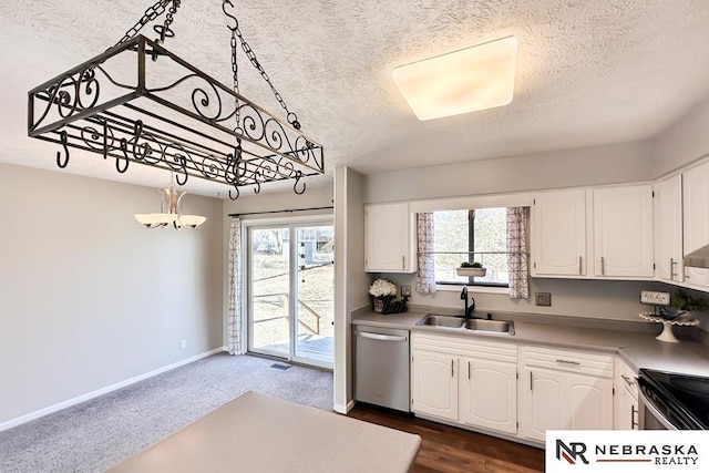 kitchen featuring baseboards, a sink, stainless steel appliances, a textured ceiling, and white cabinetry