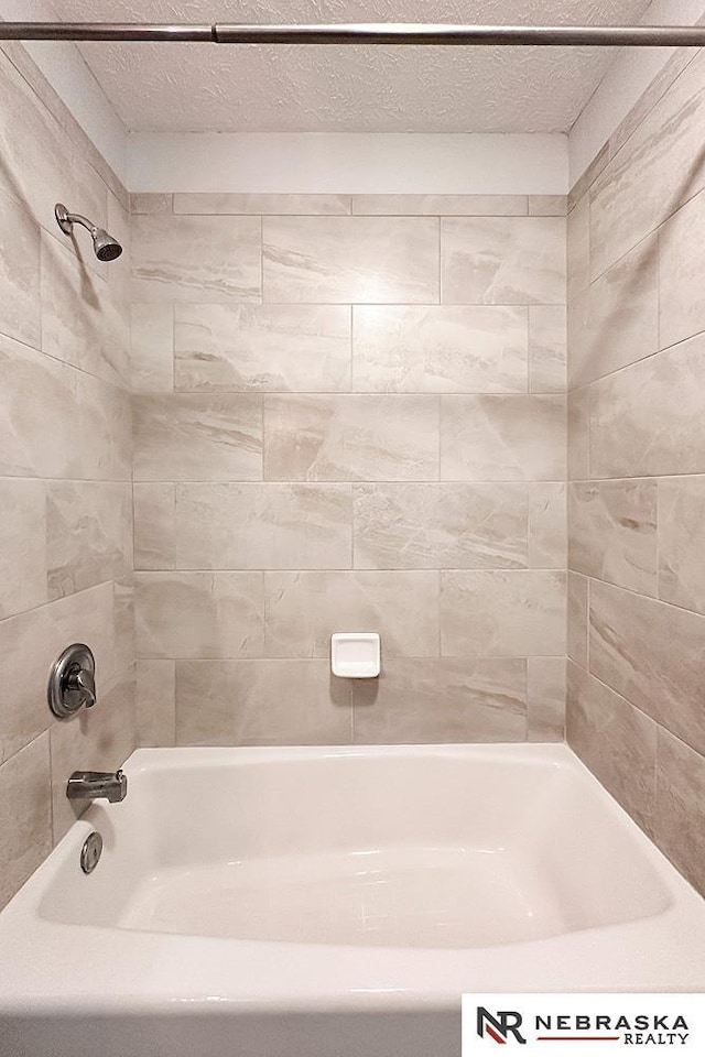 full bathroom featuring a textured ceiling and shower / bathing tub combination