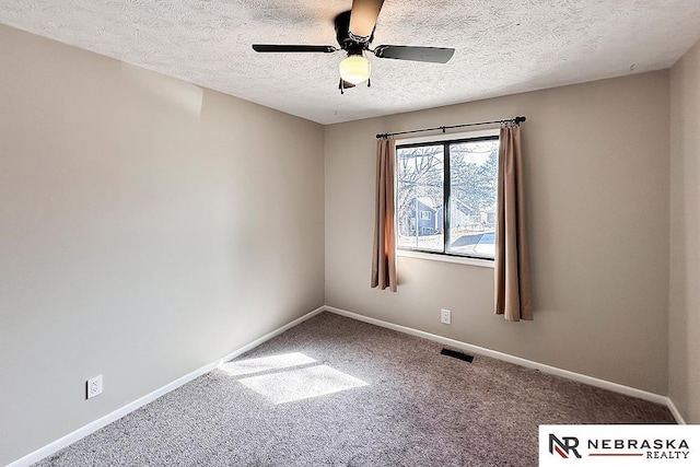 spare room with baseboards, visible vents, carpet floors, and ceiling fan