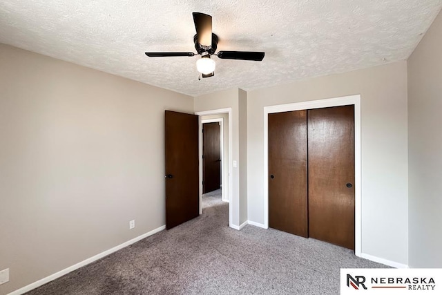 unfurnished bedroom with a textured ceiling, a closet, carpet, baseboards, and ceiling fan