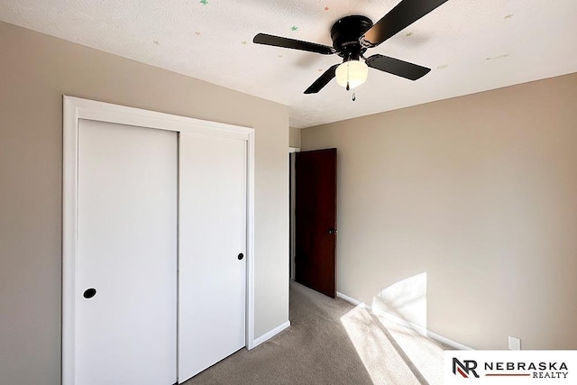 unfurnished bedroom with a ceiling fan, baseboards, a closet, a textured ceiling, and light colored carpet