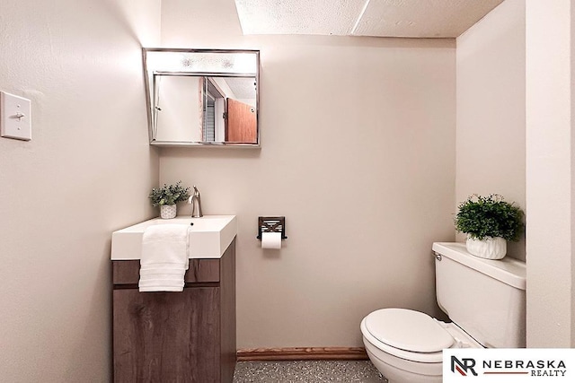 half bathroom featuring vanity, toilet, and baseboards