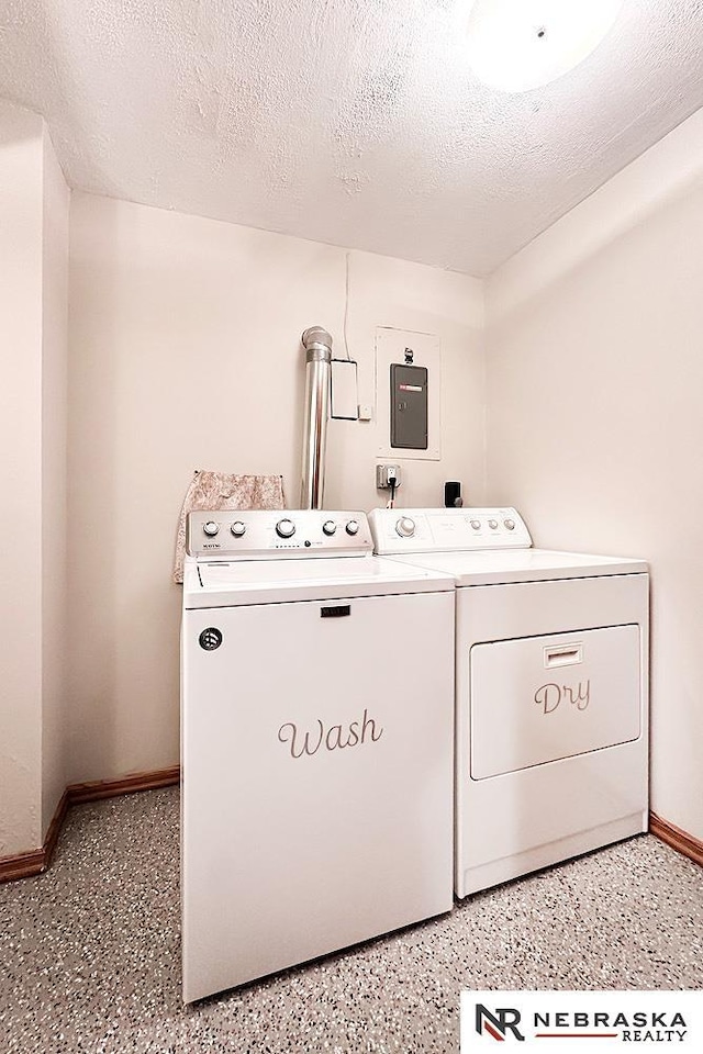 clothes washing area with washing machine and clothes dryer, laundry area, a textured ceiling, and baseboards