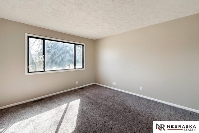 unfurnished room with visible vents, dark carpet, a textured ceiling, and baseboards