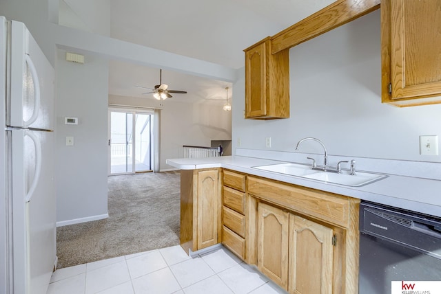 kitchen featuring freestanding refrigerator, a sink, light countertops, black dishwasher, and light carpet