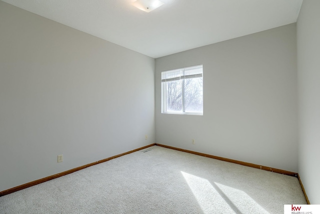 unfurnished room with carpet flooring, baseboards, and visible vents