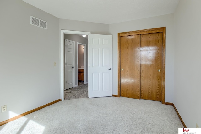 unfurnished bedroom with a closet, visible vents, baseboards, and carpet floors