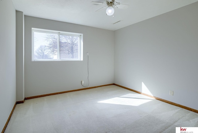 empty room with baseboards, carpet floors, visible vents, and ceiling fan