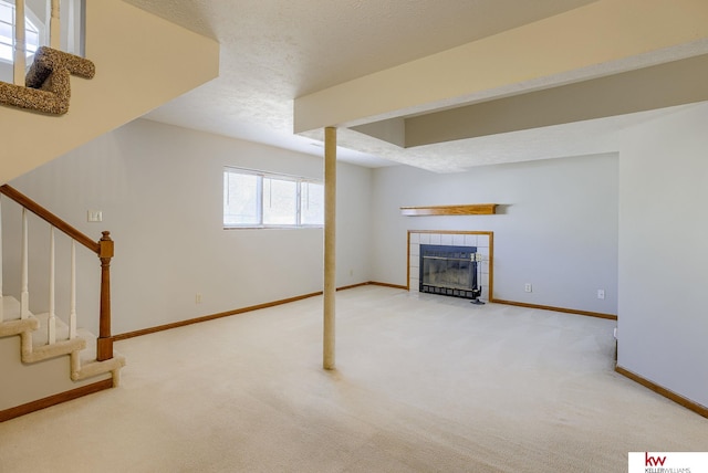 below grade area featuring stairway, baseboards, a fireplace, and carpet flooring