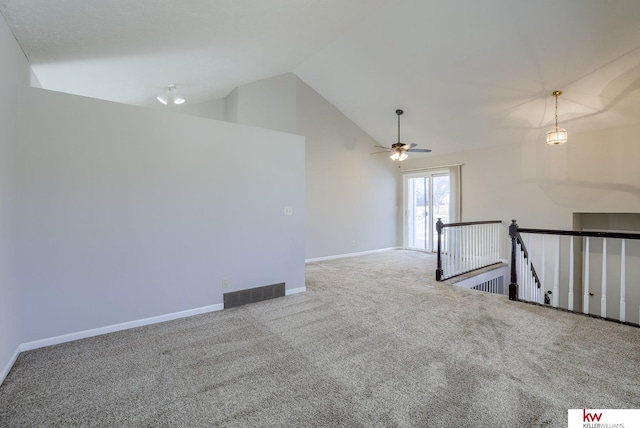 carpeted empty room with visible vents, high vaulted ceiling, baseboards, and a ceiling fan