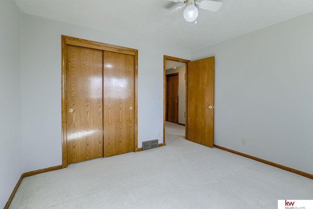 unfurnished bedroom featuring carpet flooring, baseboards, visible vents, and a closet