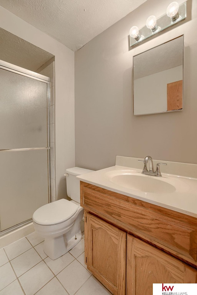 full bath featuring toilet, a stall shower, a textured ceiling, tile patterned flooring, and vanity