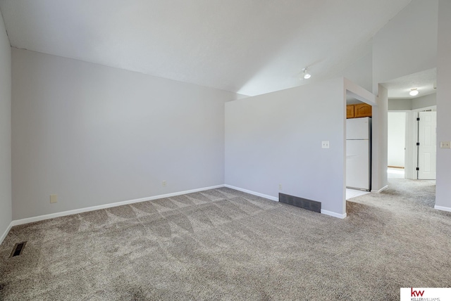 unfurnished room featuring lofted ceiling, light colored carpet, visible vents, and baseboards