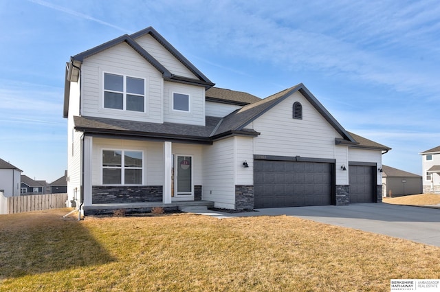 view of front facade with fence, driveway, an attached garage, a front lawn, and stone siding