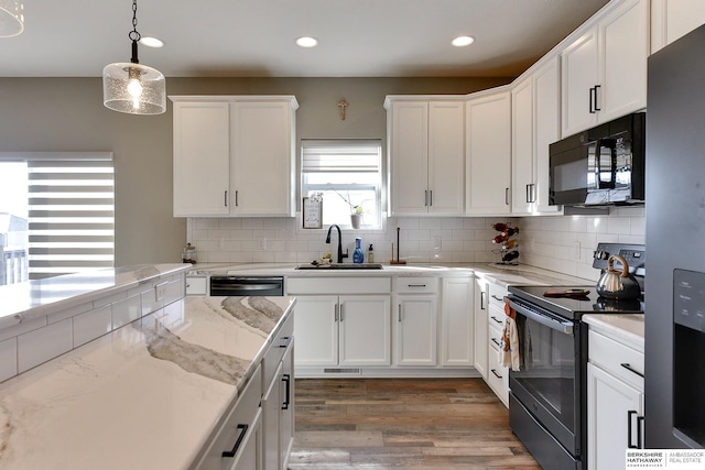 kitchen featuring a sink, tasteful backsplash, black appliances, and white cabinetry