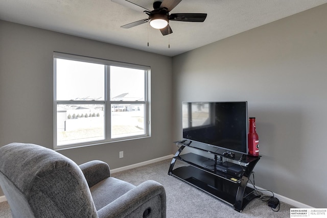 living area featuring baseboards, a healthy amount of sunlight, and carpet flooring