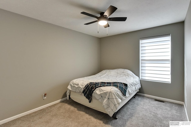 bedroom with visible vents, baseboards, carpet, and ceiling fan