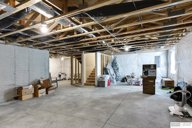 unfinished basement with electric panel and stairway