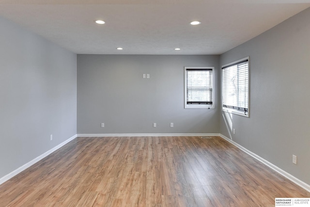 spare room featuring visible vents, recessed lighting, wood finished floors, and baseboards