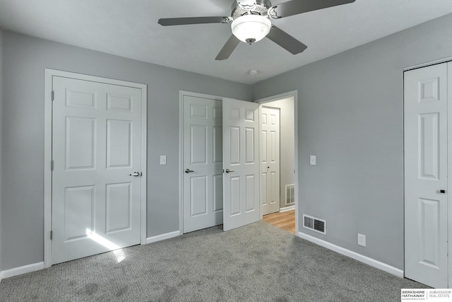 unfurnished bedroom with carpet, visible vents, and baseboards