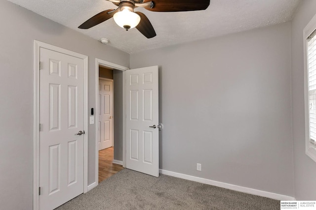 unfurnished bedroom with visible vents, baseboards, light carpet, a textured ceiling, and a ceiling fan