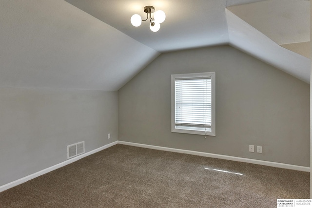 additional living space featuring vaulted ceiling, baseboards, and visible vents